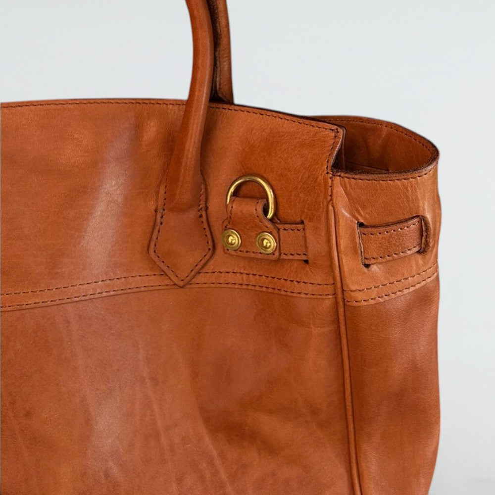 Close-up of Cleo full-grain leather, handle stitching and gold-tone attachment ring