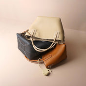 Three handbags in beige, blue, and brown on a beige background