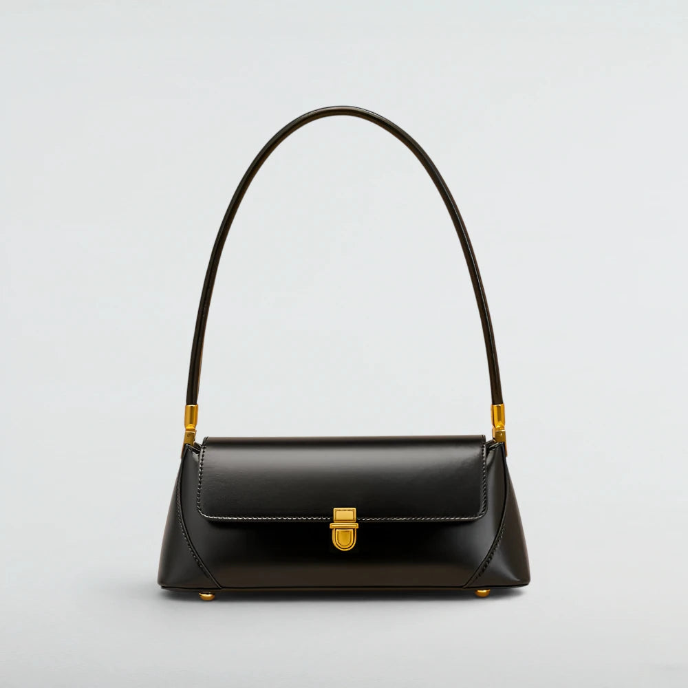 A black leather shoulder bag with a curved top handle and gold-tone hardware, shown against a light gray studio background. Laura Baguette Shoulder Bag - Bagulia