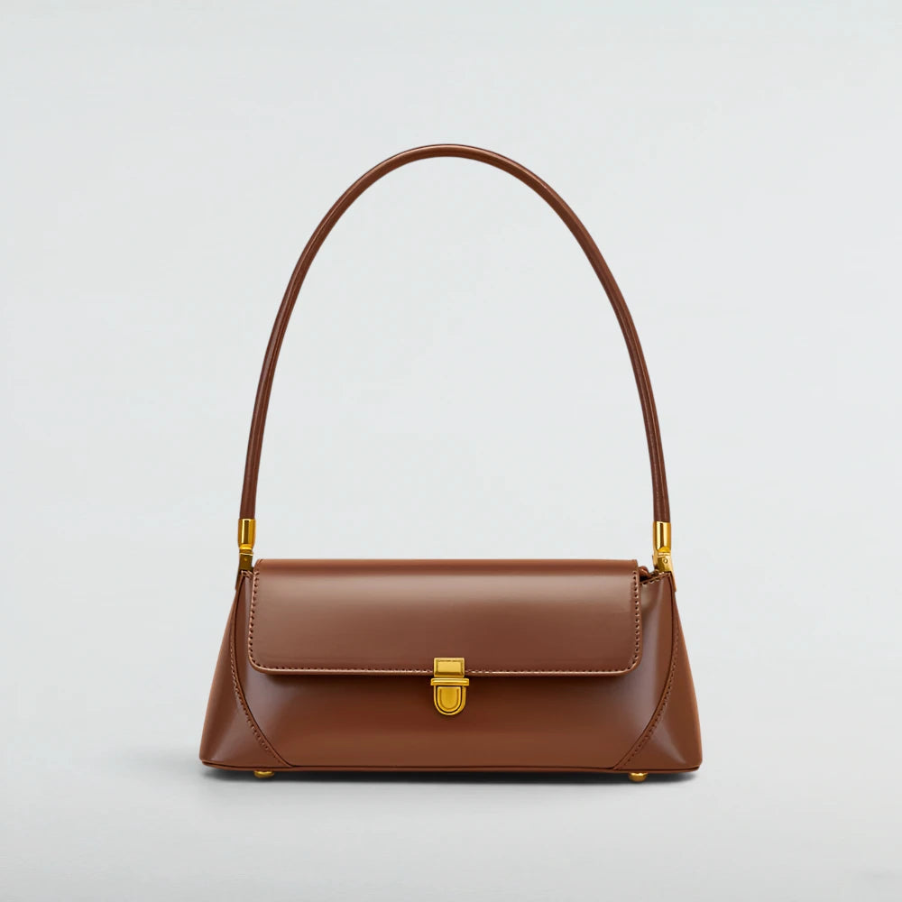 A brown leather shoulder bag with a curved top handle and a gold-tone clasp, shown against a light gray background. Laura Baguette Shoulder Bag - Bagulia