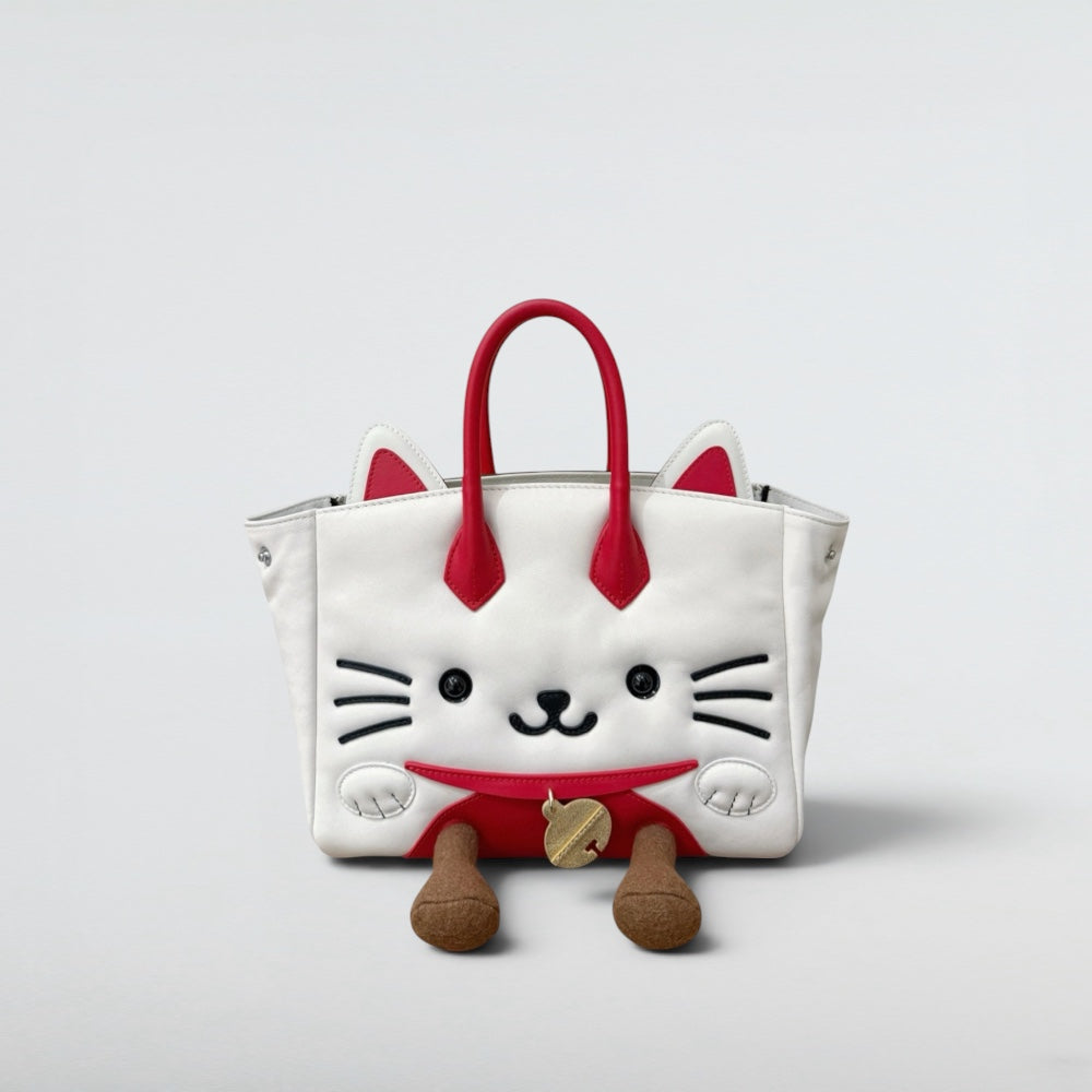 White cat-shaped bag with red accents on a light gray background. Lucky cat handbag hello kitty lookalike