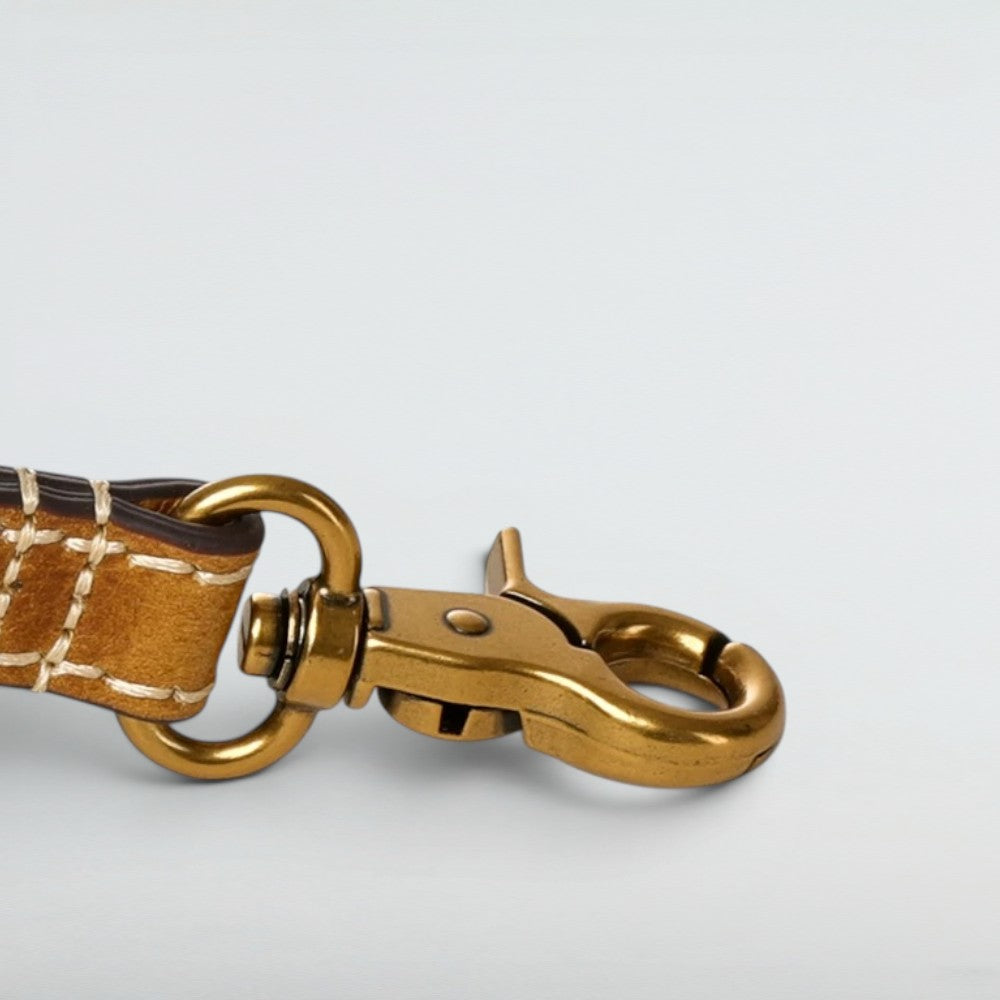 Close-up of the solid brass turn-lock hardware on the Bagulia Petra Glossy Leather Tote Bag