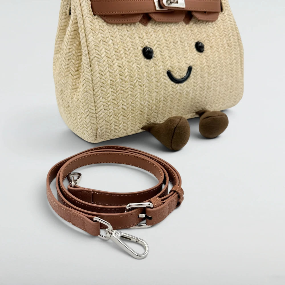 Detachable tan leather shoulder strap included with the Bagulia Birky woven straw bag