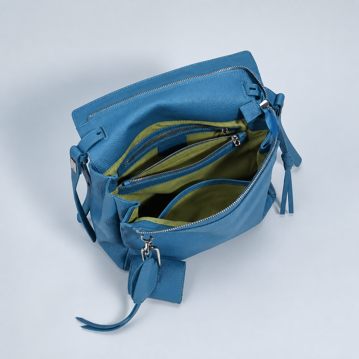 Leyla diamond blue leather shoulder bag open to show its green compartmented interior