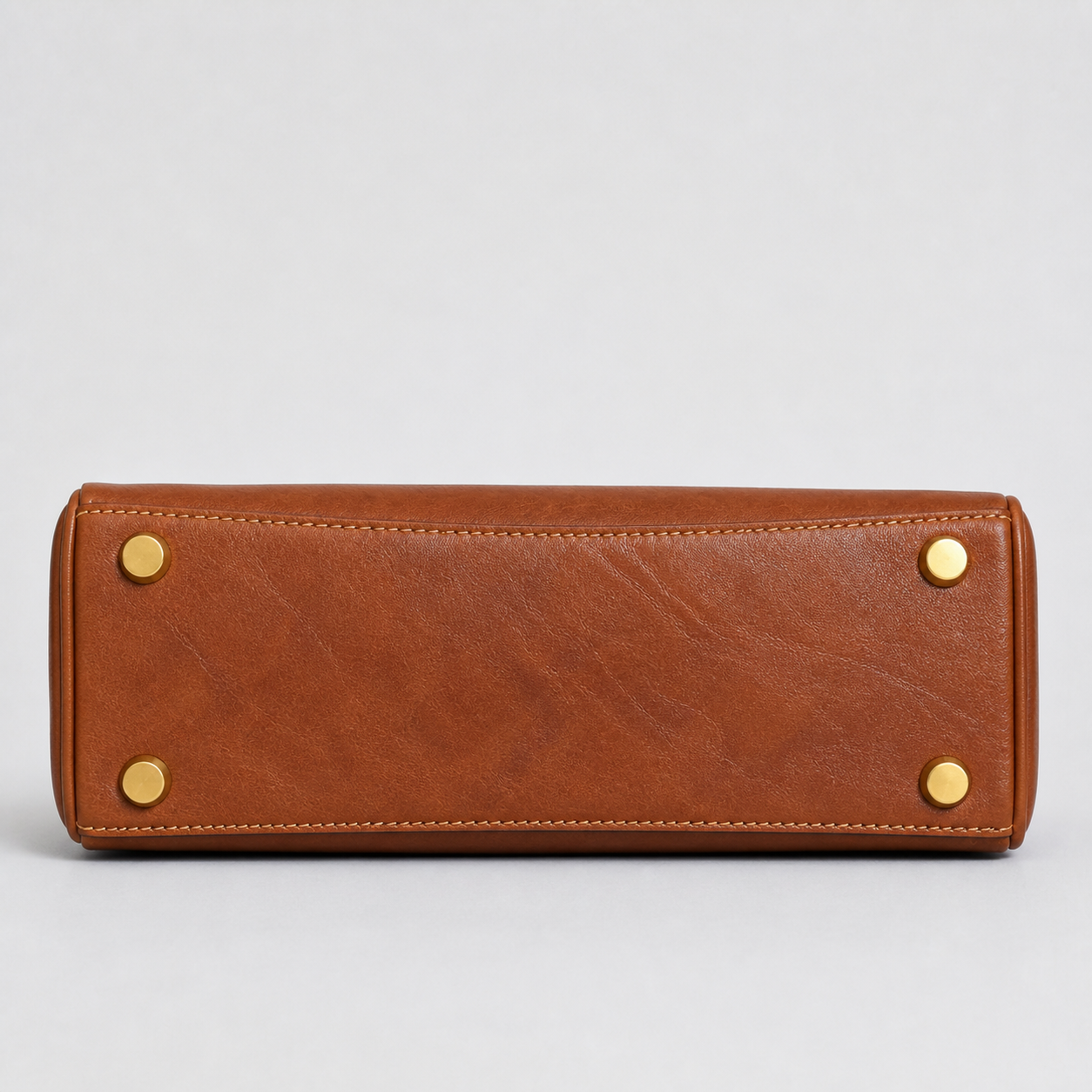 Bagulia Louve Locket Patina Bag in Cognac Brown with reinforced leather base and four protective feet