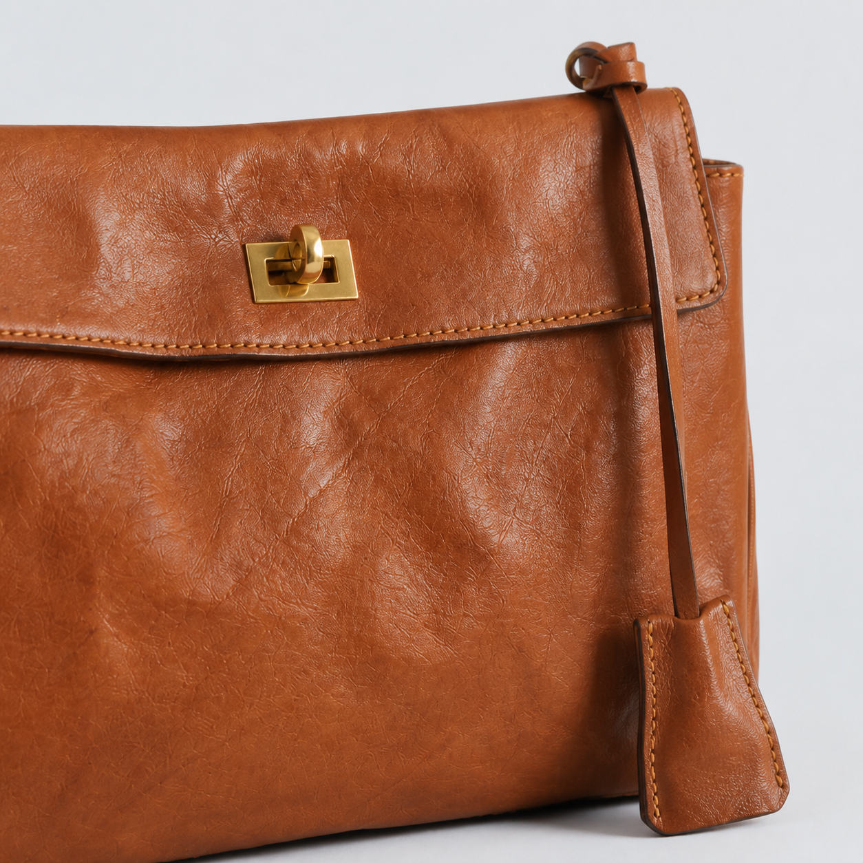 Bagulia Louve Locket Patina Bag in Cognac Brown with natural leather grain, turn-lock and key cover