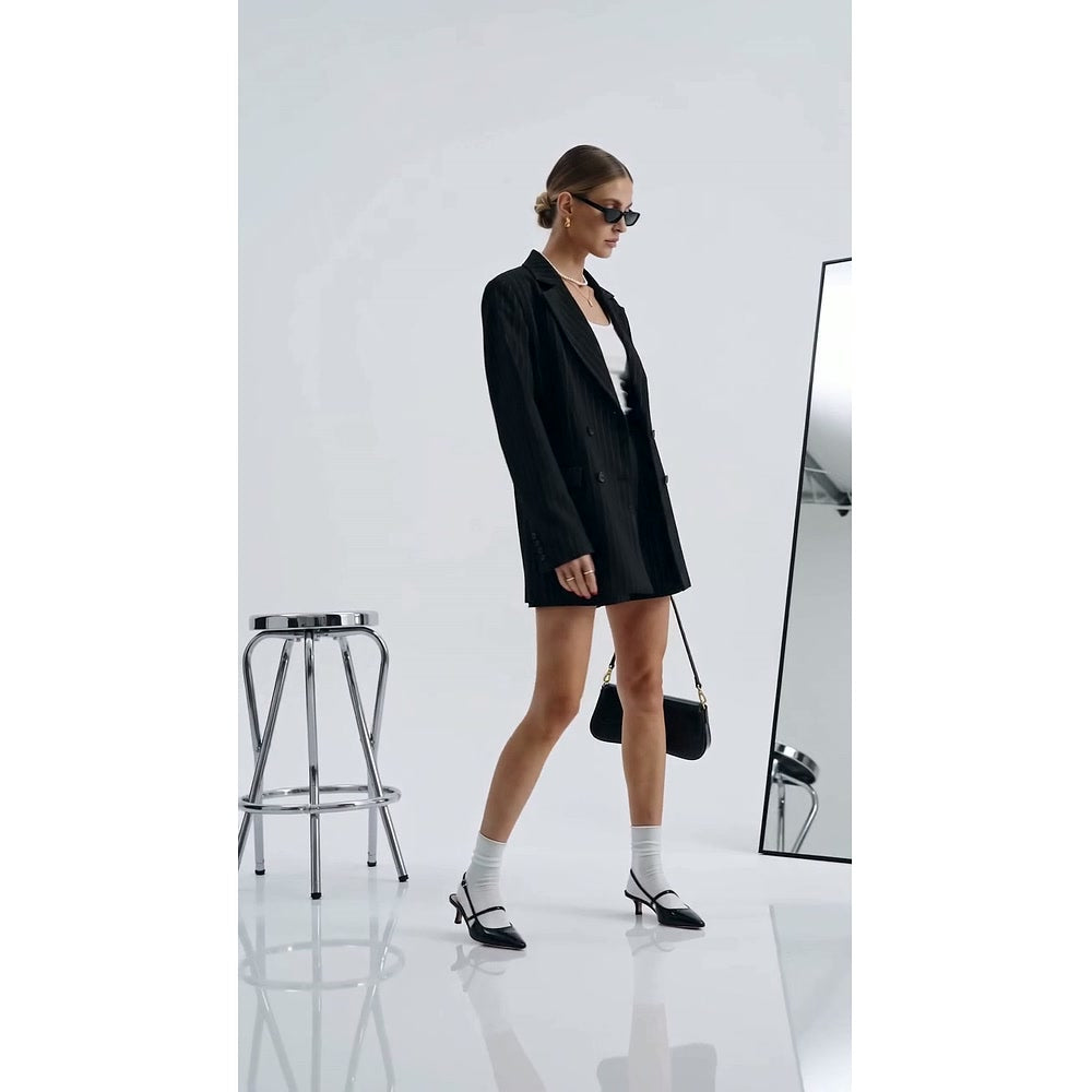 Model wearing the Bagulia Luciana black shoulder bag in a monochrome studio look