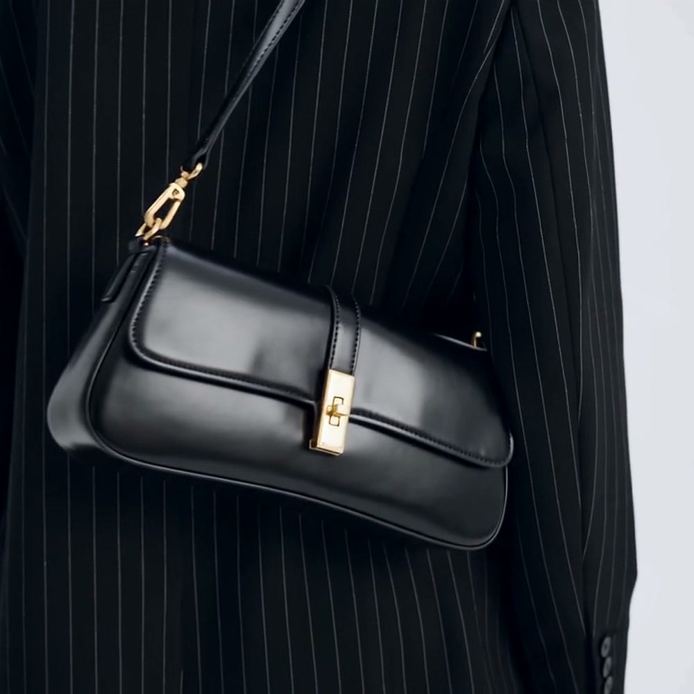 Bagulia Luciana black shoulder bag worn against a pinstripe blazer