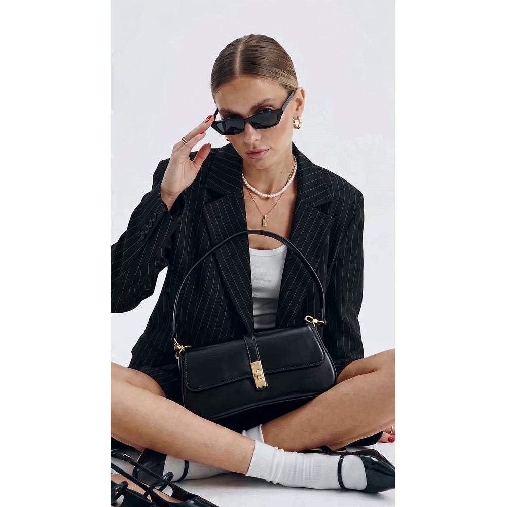 Model seated with the Bagulia Luciana black cowhide leather shoulder bag