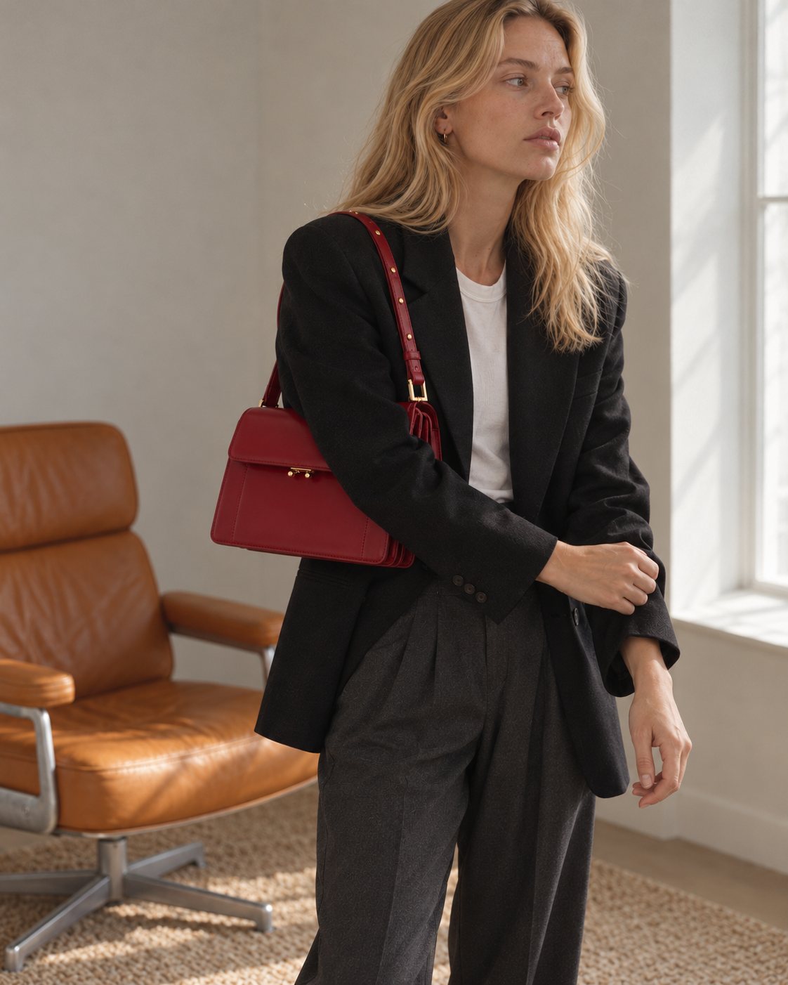 Model wearing the Bagulia Margot leather shoulder bag in red, standing view.