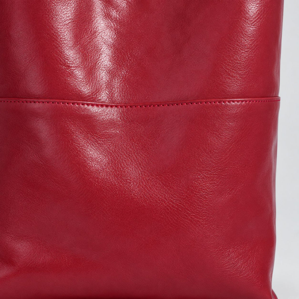 Close-up of the Marielle cherry-red tote horizontal panel seam and stitching