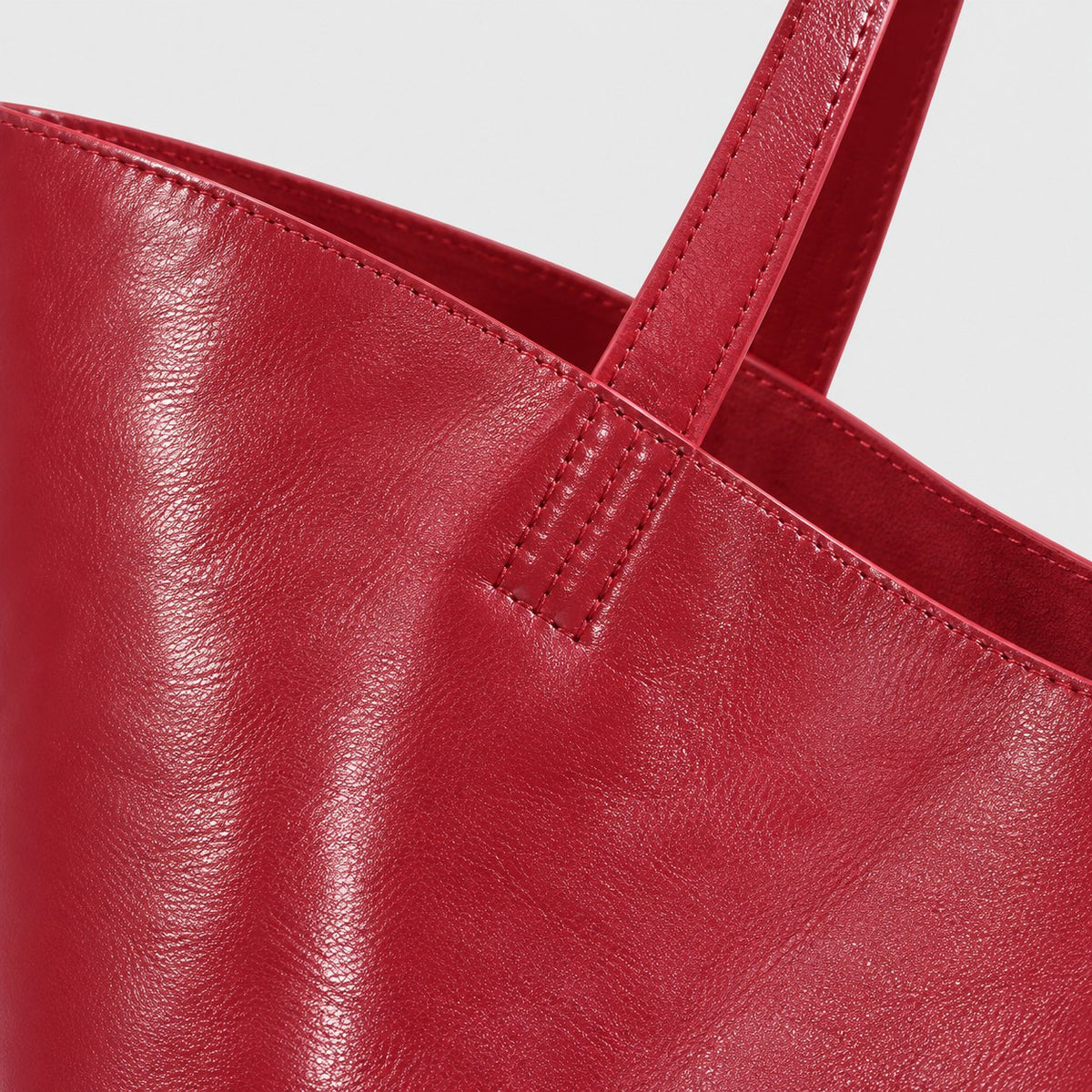 Bagulia Marielle Cherry Red tote handle detail view.