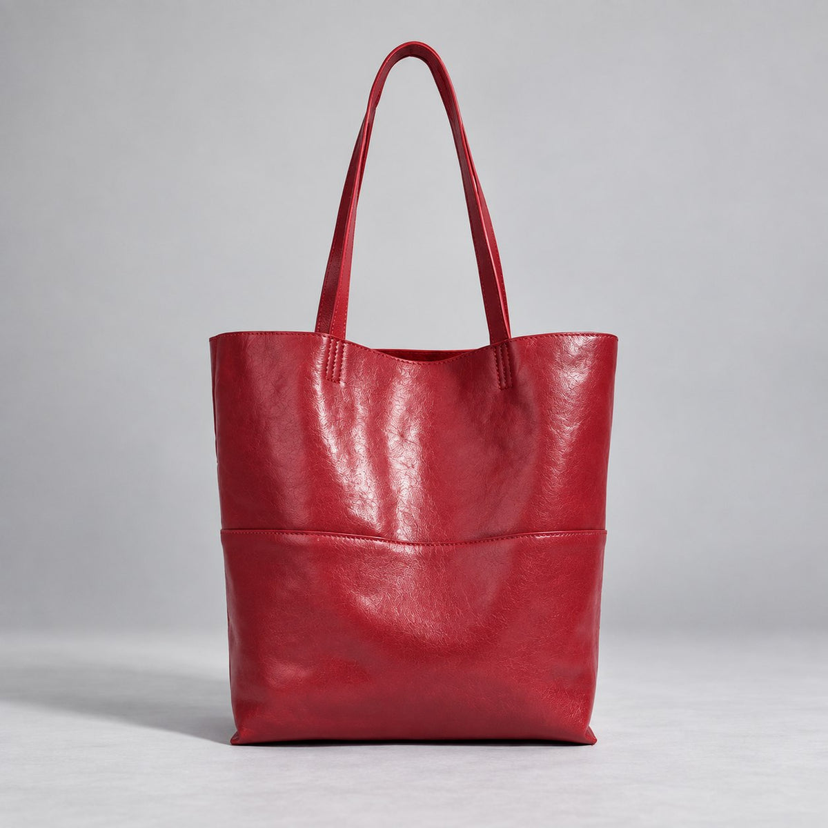 Marielle cherry-red tote with long handles and a horizontal panel seam, front view