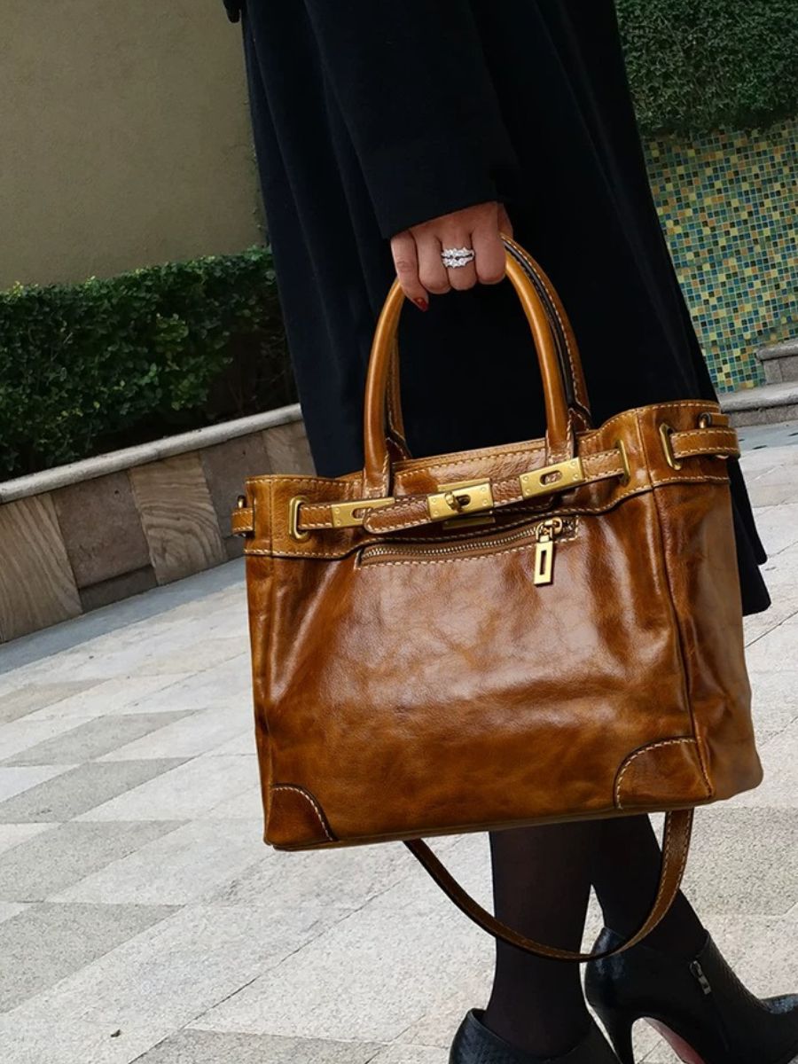 Woman carrying the Bagulia Petra Glossy Leather Tote Bag in Caramel