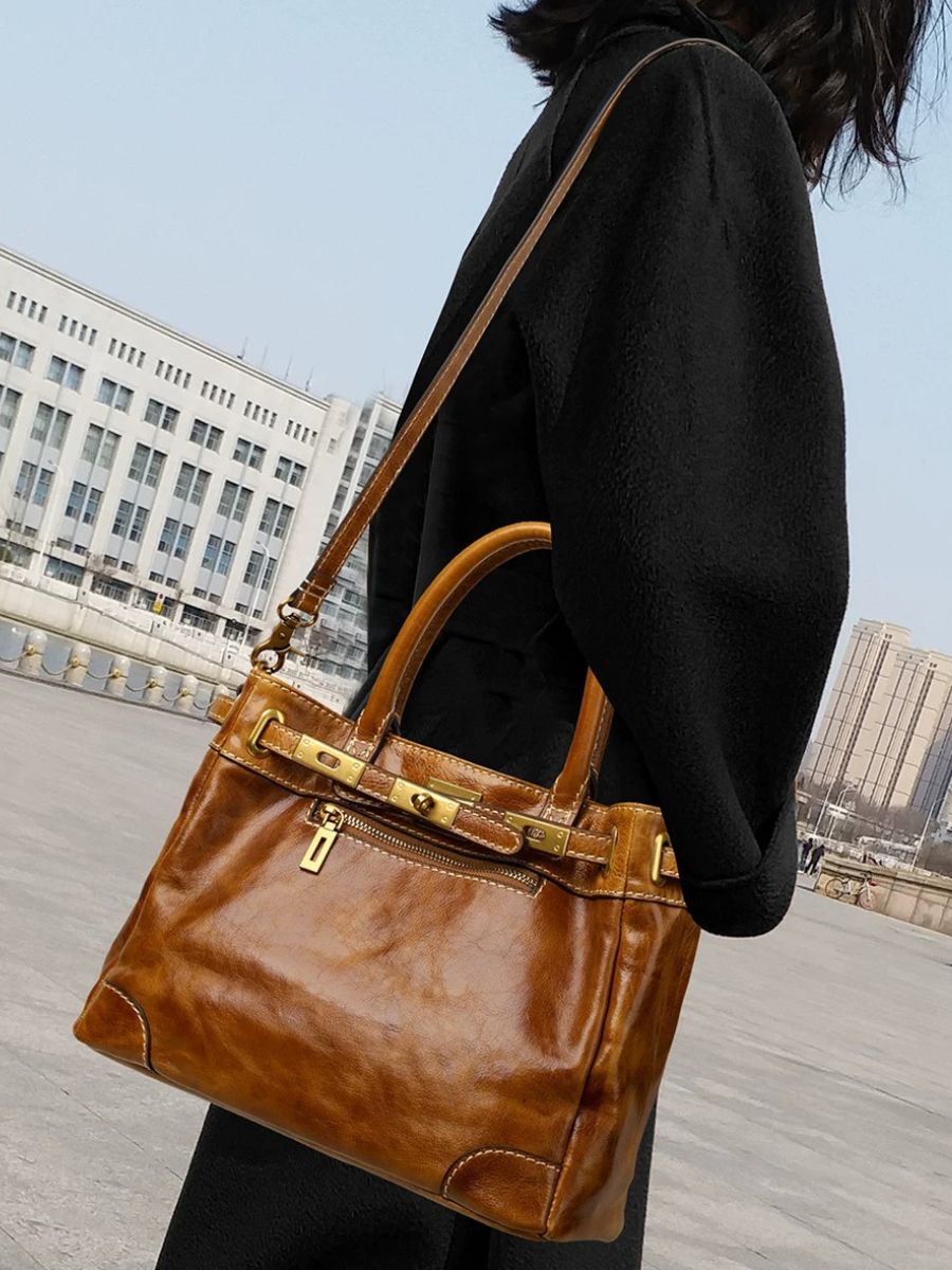 Woman carrying the Bagulia Petra Glossy Leather Tote Bag in Caramel, alternate view