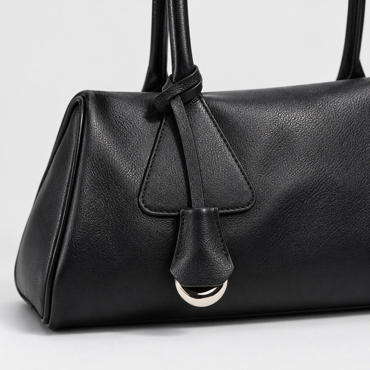 Bagulia Vera shoulder bag in black shown in handle detail view.