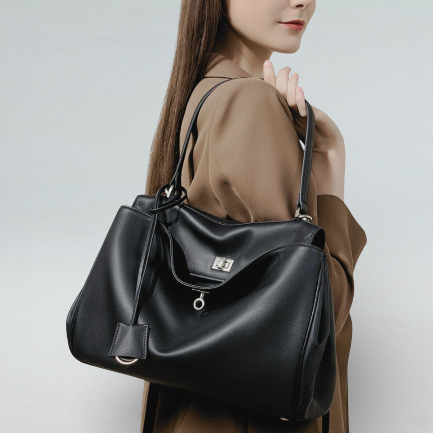 Model carrying Bagulia Louve Locket Tote Bag in Black Leather with Silver Hardware